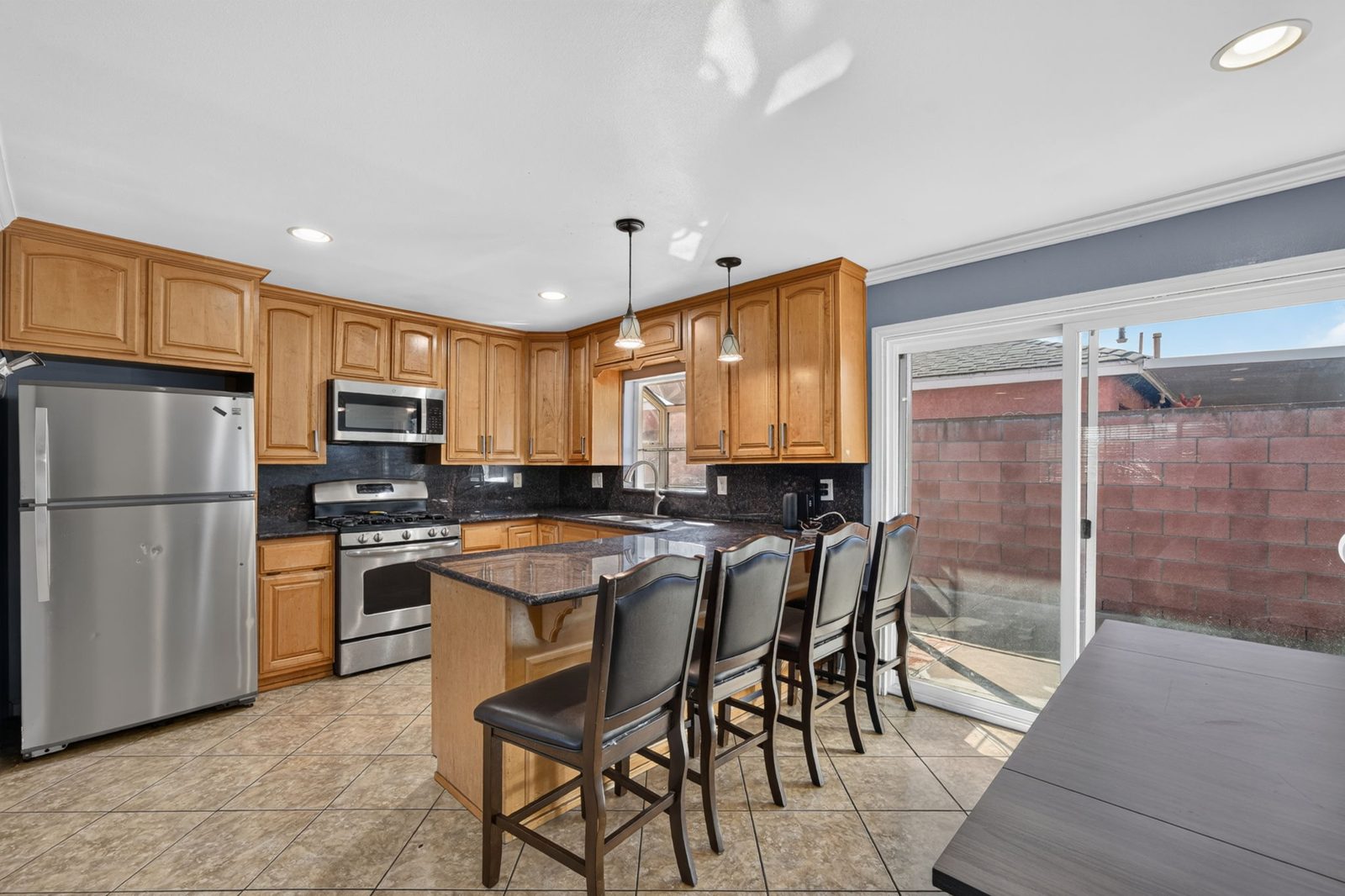 Kitchen with granite counters, maple cabinetry, breakfast bar and stainless appliances